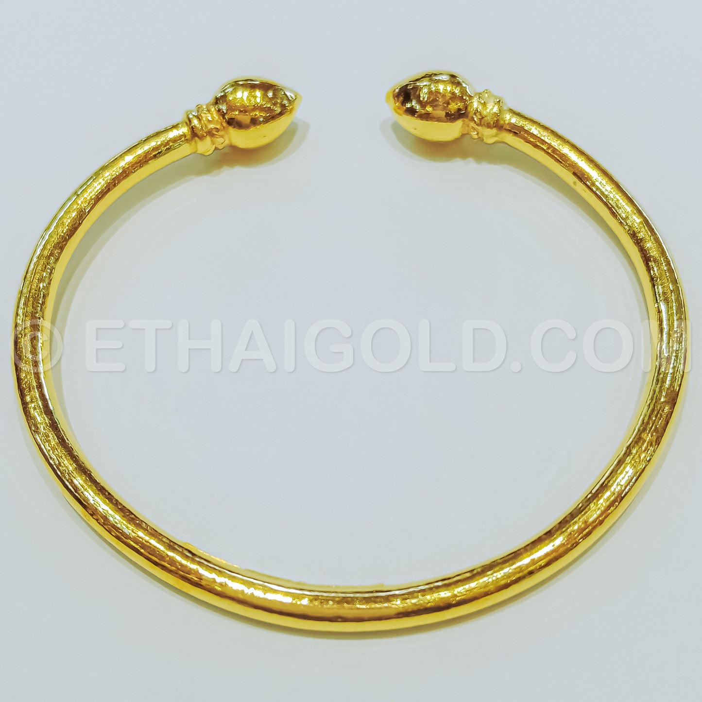 Woman's hand holding thai gold bracelet design. | CanStock